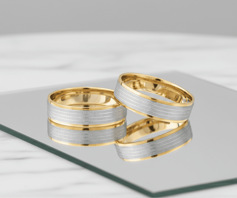 Modernaus dizaino auksiniai vestuviniai žiedai su minimalistinėmis detalėmis.